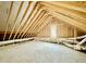 Unfinished attic space with wooden beams and a small window at 3315 Hampton Rd, Raleigh, NC 27607