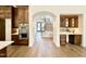 Hallway view featuring an arched entryway, stairs, hardwood floors, and a built-in bar area at 3315 Hampton Rd, Raleigh, NC 27607