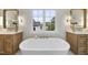 Beautiful bathroom featuring dual vanities, a freestanding tub, and a large window at 3317 Hampton Rd, Raleigh, NC 27607