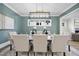 Elegant dining room features a modern light fixture, calming teal walls, and seating for eight people at 3317 Hampton Rd, Raleigh, NC 27607