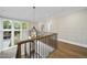 A naturally lit upstairs hallway featuring a decorative light fixture and wooden floors at 3317 Hampton Rd, Raleigh, NC 27607