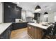 This expansive kitchen features an island with seating, dark cabinetry, quartz countertops, and stainless appliances at 3317 Hampton Rd, Raleigh, NC 27607