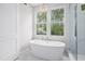 Bright bathroom featuring a soaking tub and separate glass enclosed shower at 4005 Brevard Pl, Raleigh, NC 27609