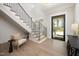 Inviting foyer with wood floors, staircase with black railings, and ample natural light at 4005 Brevard Pl, Raleigh, NC 27609