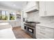 Bright kitchen features a window, white cabinets, marble backsplash, and a large stainless steel stove at 4005 Brevard Pl, Raleigh, NC 27609