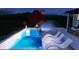 A modern backyard pool with a spa, lighted spheres, in-pool lounge chairs and hanging swing-bed at 4005 Brevard Pl, Raleigh, NC 27609