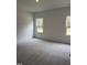 Bright bedroom with carpeted floors and two windows at 507 Barnes Landing Dr, Four Oaks, NC 27524