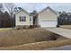 Beige house with a two-car garage and stone accents at 507 Barnes Landing Dr, Four Oaks, NC 27524