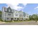 Townhomes with gray and white siding, stone accents, and neatly landscaped yards at 701 Lucky Clover Way, Fuquay Varina, NC 27526