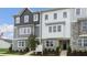 Two-story townhome with gray and white siding, landscaping, and American flag at 703 Lucky Clover Way, Fuquay Varina, NC 27526