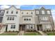 Three-story townhouses with neutral siding and landscaping at 705 Lucky Clover Way, Fuquay Varina, NC 27526