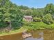 Aerial view of home nestled on the lake, featuring a private dock at 10305 Old Creedmoor Rd, Raleigh, NC 27613