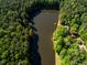 Aerial view of lakefront home nestled in the woods at 10305 Old Creedmoor Rd, Raleigh, NC 27613