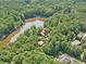 Aerial view of house on a lake with lush green trees surrounding the property at 10305 Old Creedmoor Rd, Raleigh, NC 27613