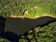 An aerial view of a house on a lake with surrounding trees at 10305 Old Creedmoor Rd, Raleigh, NC 27613