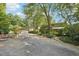 Home exterior showcasing a spacious driveway and lush landscaping at 10305 Old Creedmoor Rd, Raleigh, NC 27613
