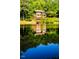 Stunning reflection of lake house on calm water at 10305 Old Creedmoor Rd, Raleigh, NC 27613