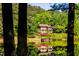 Lake house partially obscured by trees, showcasing waterfront living at 10305 Old Creedmoor Rd, Raleigh, NC 27613