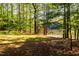Wooded lot with a tranquil lakeside setting and grassy area at 10305 Old Creedmoor Rd, Raleigh, NC 27613
