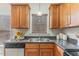 Well-lit kitchen featuring stainless steel sink, granite counters, wooden cabinets, and modern appliances at 110 Citrine Ct, Knightdale, NC 27545