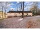 View of the back of the house featuring cream siding and a beautiful wooded lot at 1109 Mays Chapel Rd, Bear Creek, NC 27207