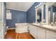 En suite bathroom features a tub, double-sink vanity, hardwood flooring, and natural light at 1109 Mays Chapel Rd, Bear Creek, NC 27207