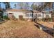 View of a single Gathering home featuring neutral siding, brick foundation, and an overgrown front yard at 1109 Mays Chapel Rd, Bear Creek, NC 27207