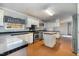 Kitchen with island, stainless steel appliances, black tiled countertops, and white cabinets at 1109 Mays Chapel Rd, Bear Creek, NC 27207