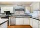 Eat in kitchen area with stainless steel appliances and black tiled backsplash at 1109 Mays Chapel Rd, Bear Creek, NC 27207
