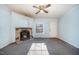 Living room featuring a stone fireplace, a window, a ceiling fan, and access to the front door at 1109 Mays Chapel Rd, Bear Creek, NC 27207