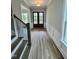 Hallway with hardwood floors leading to a double door entrance and a staircase at 1229 Azalea Garden Cir, Raleigh, NC 27603