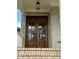 Elegant wood double front doors with glass panes, framed by brick and overhead lighting at 1229 Azalea Garden Cir, Raleigh, NC 27603