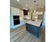 Spacious kitchen with a center island, white cabinets, stainless appliances, and hardwood floors at 1229 Azalea Garden Cir, Raleigh, NC 27603