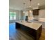 Modern kitchen with a large island, stainless steel appliances, and stylish pendant lighting at 1229 Azalea Garden Cir, Raleigh, NC 27603