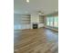 Inviting living room featuring a fireplace, built-in shelving, hardwood floors, and large windows at 1229 Azalea Garden Cir, Raleigh, NC 27603