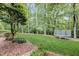 Landscaped backyard with a trampoline and wooded area at 1300 Caistor Ln, Raleigh, NC 27614