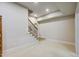 Unfinished basement with carpeted floors and a wooden staircase at 1300 Caistor Ln, Raleigh, NC 27614
