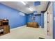 Finished basement room with blue walls, a couch, and built-in shelving at 1300 Caistor Ln, Raleigh, NC 27614