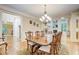 Bright dining room with hardwood floors, chandelier, and views into the living room at 1300 Caistor Ln, Raleigh, NC 27614