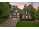 Stately stone home with manicured landscaping, a red front door, and abundant natural light at 1300 Caistor Ln, Raleigh, NC 27614