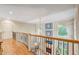 Elegant curved hallway with hardwood floors and an iron railing at 1300 Caistor Ln, Raleigh, NC 27614