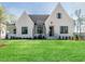 White brick home with a gabled roof, black windows, and a manicured lawn at 131 Evander Way, Pittsboro, NC 27312