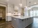 Modern kitchen with white and gray cabinets and a large island at 131 Evander Way, Pittsboro, NC 27312