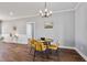 A dining area with modern yellow chairs and hardwood floors, seamlessly connects to other rooms at 137 Glenwood Pl, Kenly, NC 27542