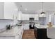 Bright kitchen features white cabinetry, granite countertops, stainless appliances, and dark hardwood floors at 137 Glenwood Pl, Kenly, NC 27542