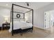 Bright bedroom with a four-poster bed, neutral rug, and bench seating at 221 Old Hickory Dr, Raleigh, NC 27603