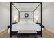 Bedroom with a four-poster bed, white linens, and neutral-toned accents at 221 Old Hickory Dr, Raleigh, NC 27603