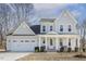 Charming two-story home featuring a covered porch with white columns and an attached two-car garage at 221 Old Hickory Dr, Raleigh, NC 27603