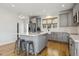 Modern kitchen featuring an island with seating and grey cabinets and stainless appliances at 221 Old Hickory Dr, Raleigh, NC 27603