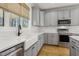 Bright kitchen with stainless steel appliances, farmhouse sink and gray cabinets at 221 Old Hickory Dr, Raleigh, NC 27603